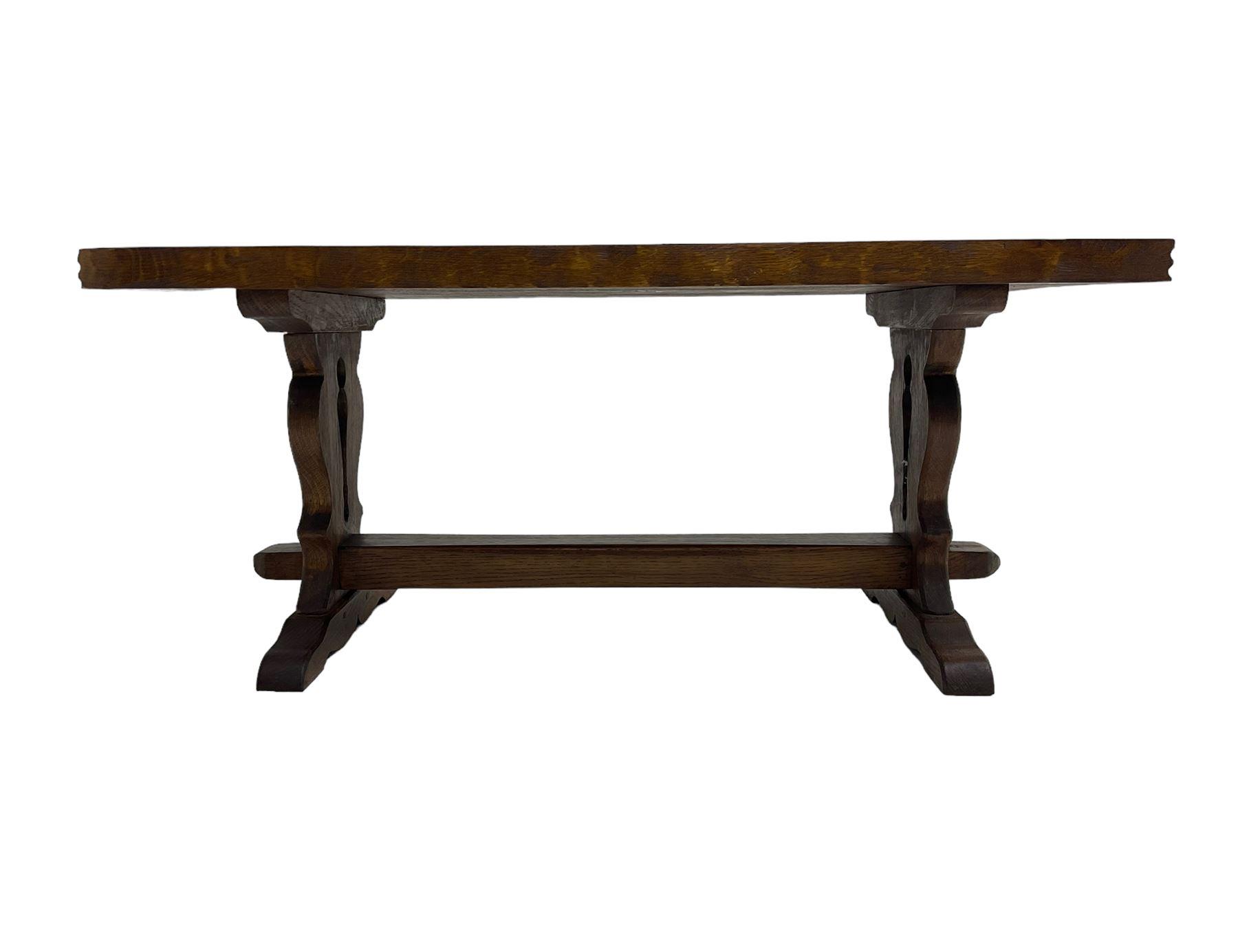 Solid oak coffee table, rectangular waved cut top with tooled ends, on shaped and pierced end supports joined by pegged stretcher 