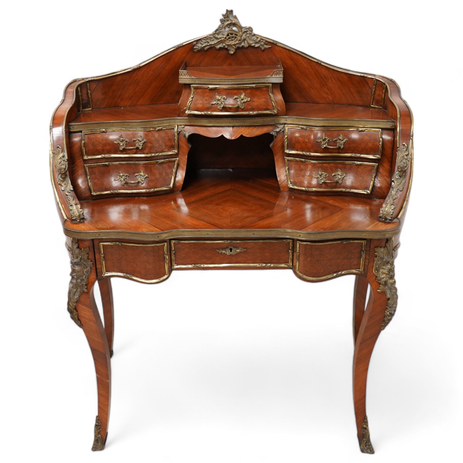 Early 20th century Louis XV design Kingwood and ormolu mounted bonheur du jour, shaped raised back fitted with five drawers and central recess, surmounted by scrolling foliate casting and pierced gallery, single frieze drawer with sliding top inset with crushed velvet, on cabriole supports mounted by mask castings with extending floral decoration, the sides and drawer fronts inlaid with parquetry panels 