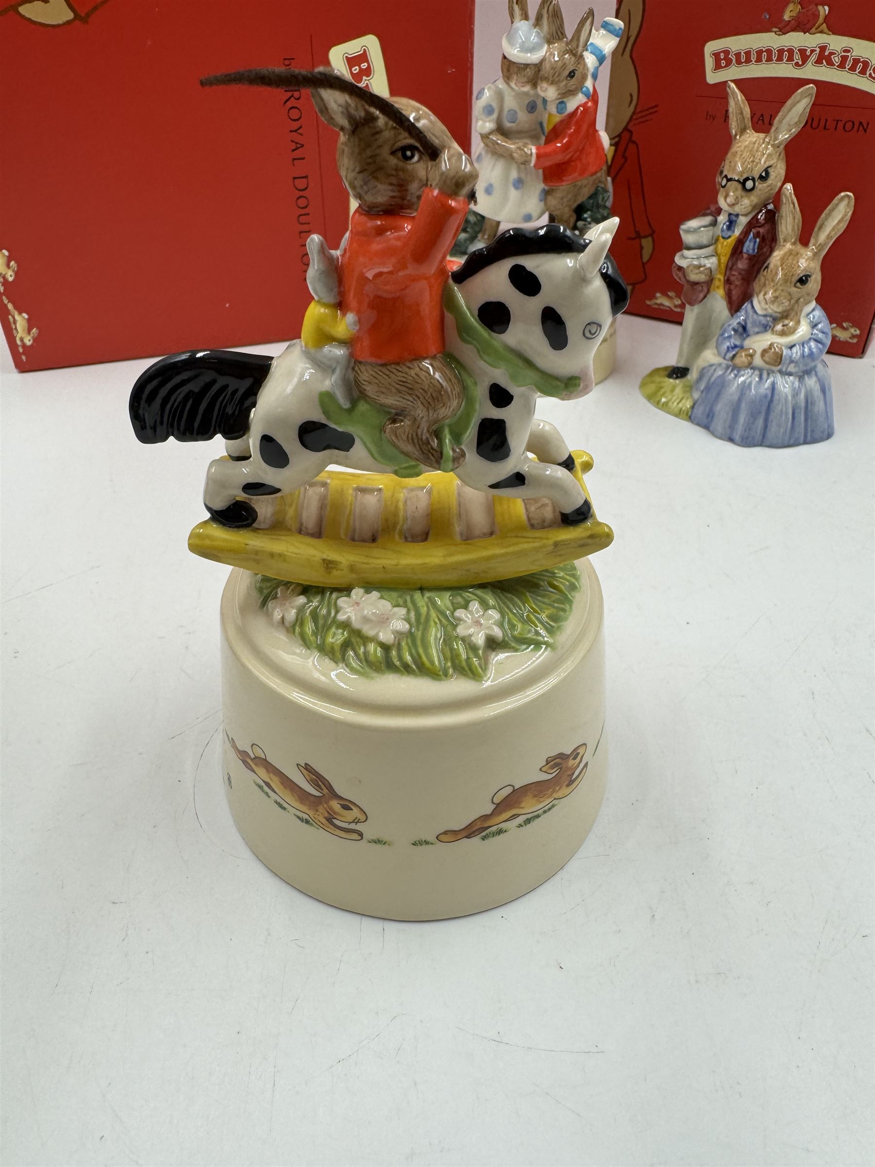 Two Royal Doulton Bunnykins music boxes, comprising Rocking Horse and Winter Waltz together with two Royal Doulton Bunnykins figures Once Upon a Time and Father, Mother & Victoria, all with original boxes  