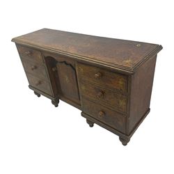 Victorian walnut scumbled pine sideboard, stepped rectangular top over central cupboard with marquetry inlay, flanked by two banks of three drawers fitted with round wooden knobs, raised on turned bun supports