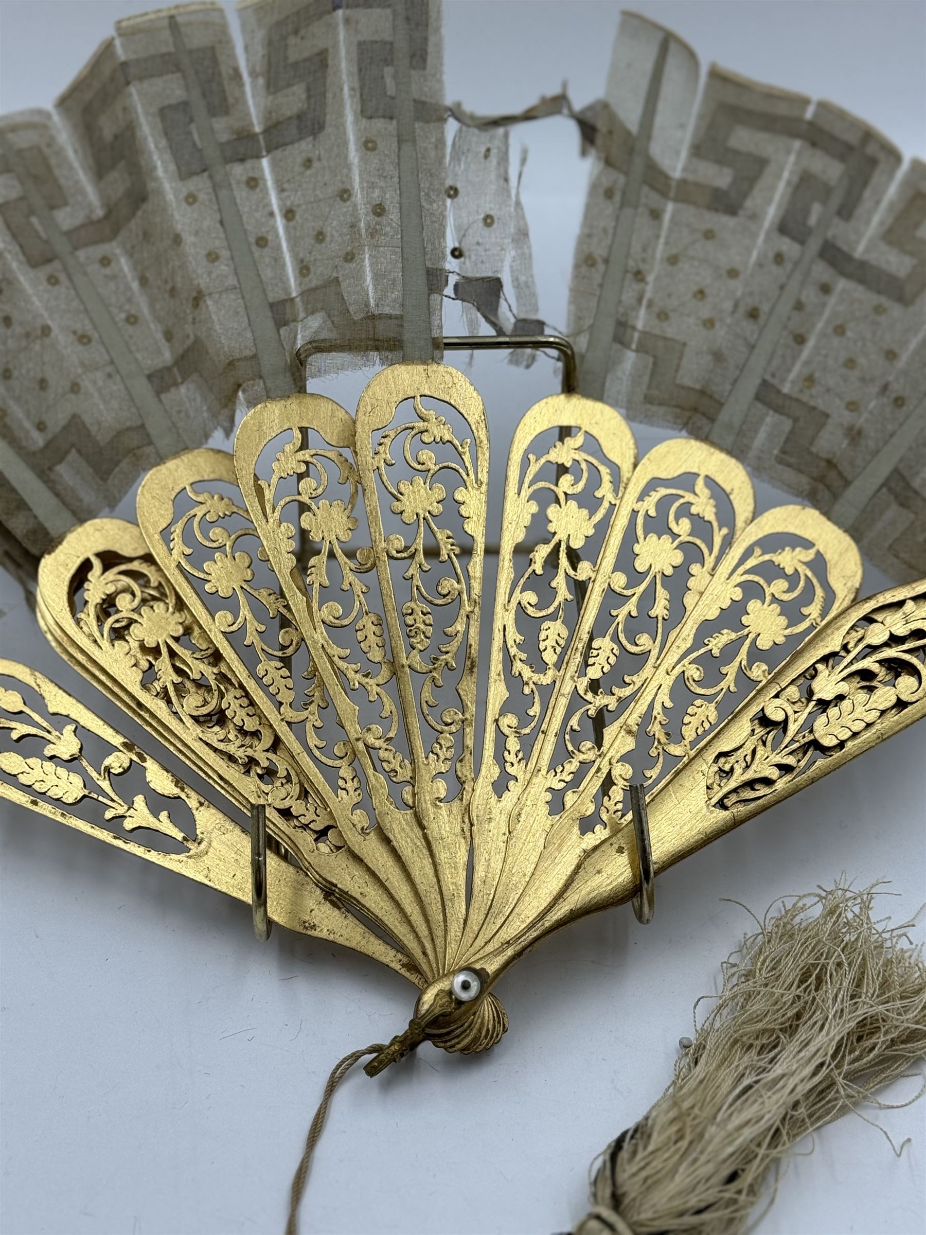 19th century carved gilt wood fan by Eugene Rimmel, the guards and sticks with pierced floral decoration, the chiffon leaf worked with sequins, with silk beaded tassel, stamped E.Rimmel 36 Strand London, with a purple silk lined box 