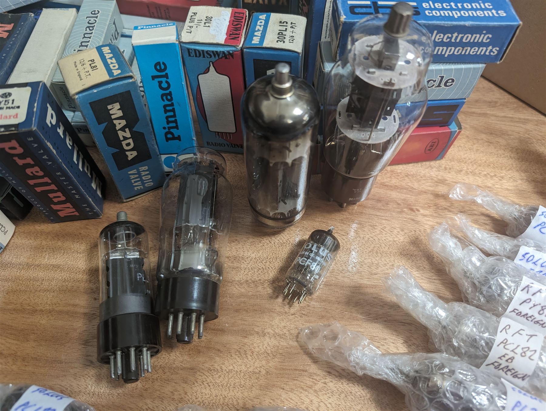 Large collection of thermionic valves/vacuum tubes, by various makers, mostly wrapped in bubble wrap with identifying stickers, together with a collection of empty valve boxes including Pinnacle, Mullard etc