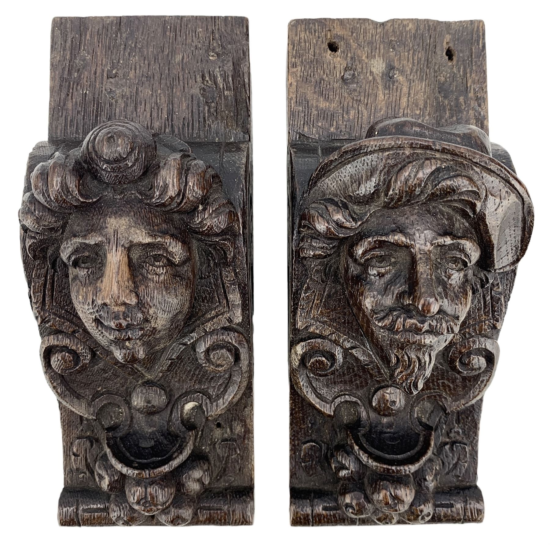 Pair of Victorian figural carved oak corbels, modelled as male and female masks, with scroll and fruit details, H22cm x W8.5cm 