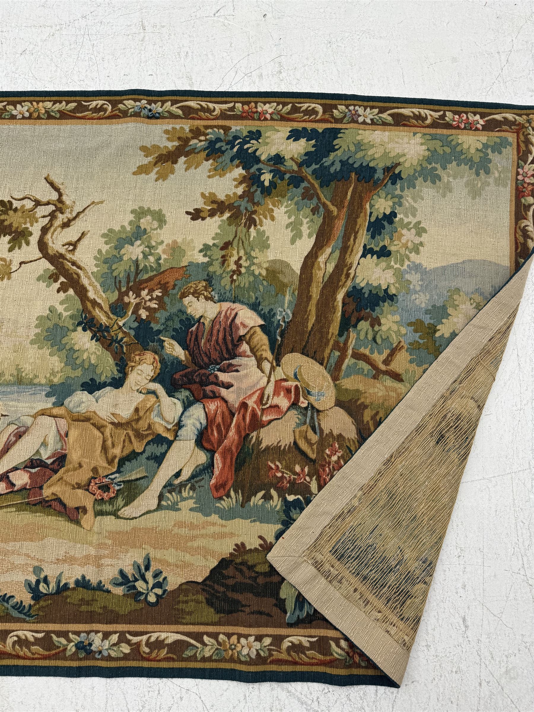 Large French machine woven tapestry, depicting figures in a landscape with a floral boarder 