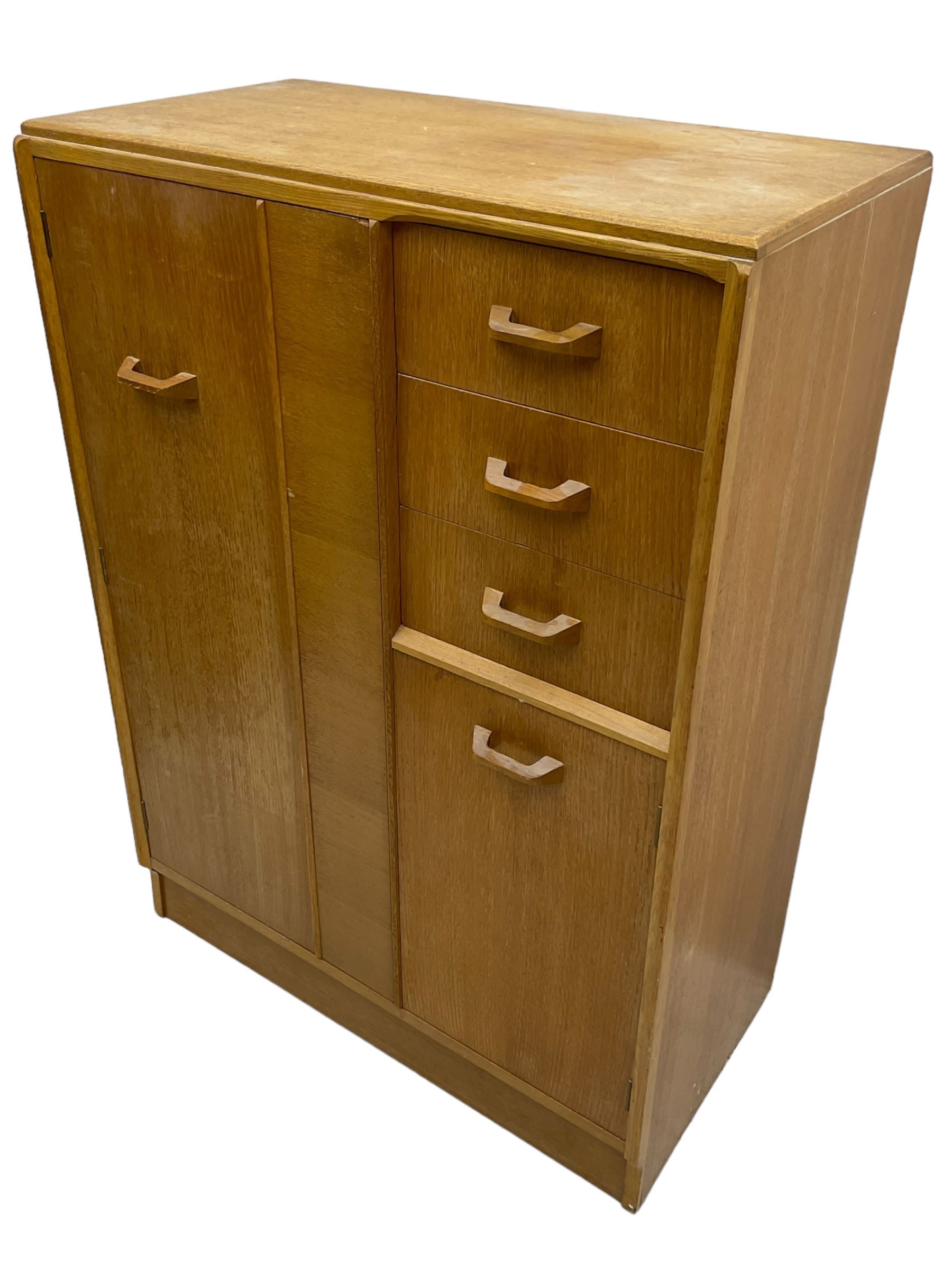 G-Plan - mid 20th century teak tallboy or combination wardrobe, left side with full-height hanging cupboard, right side with three drawers, the top fitted with vanity mirror, above cupboard with shelves, raised on a plinth base