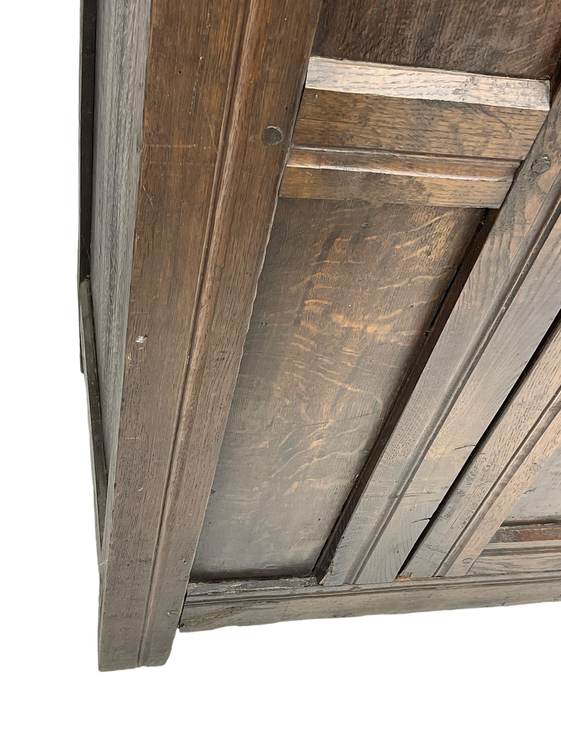 17th century and later oak hall cupboard, panelled front and sides with moulded frame, enclosed by single door with wrought metal hinges and handle, the interior fitted with hooks, on stile supports 