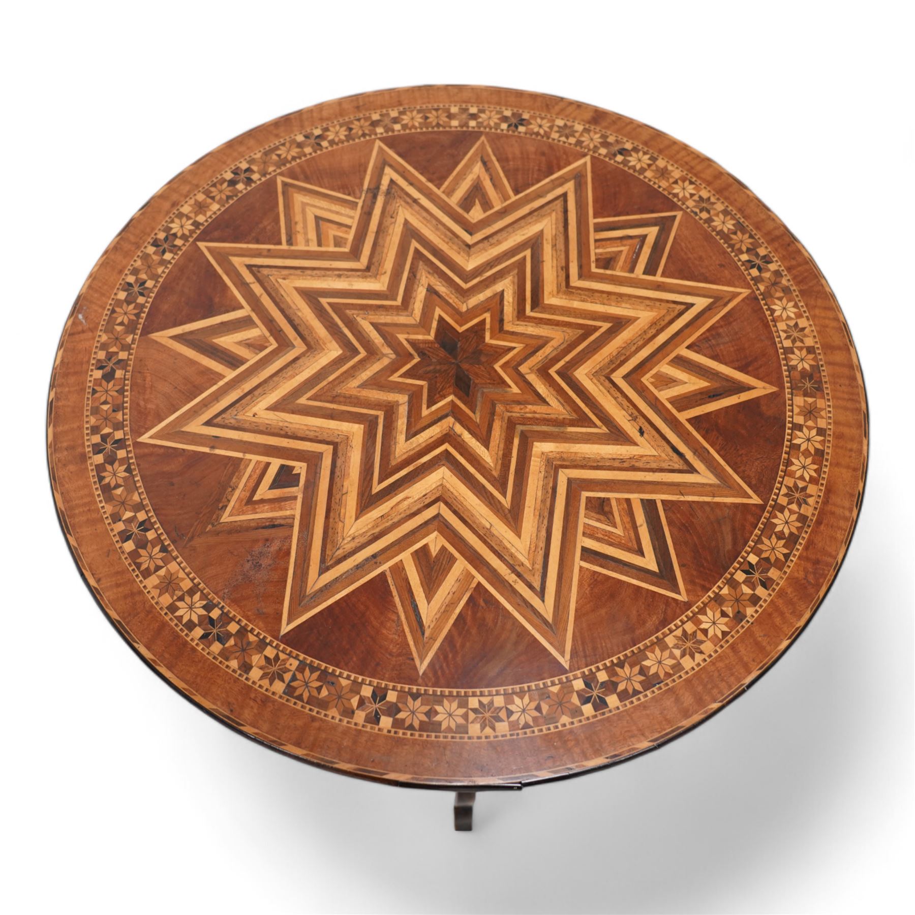 19th century inlaid walnut Italian Sorrento table, circular tilt-top with geometric star inlay and parquetry band decorated with stylised flowerheads, on turned column with three out splayed silhouette supports 