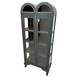 Tall painted glazed display cabinet, double arched top over two glazed doors, fitted with three shelves, in rustic blue paint finish, on cabriole feet