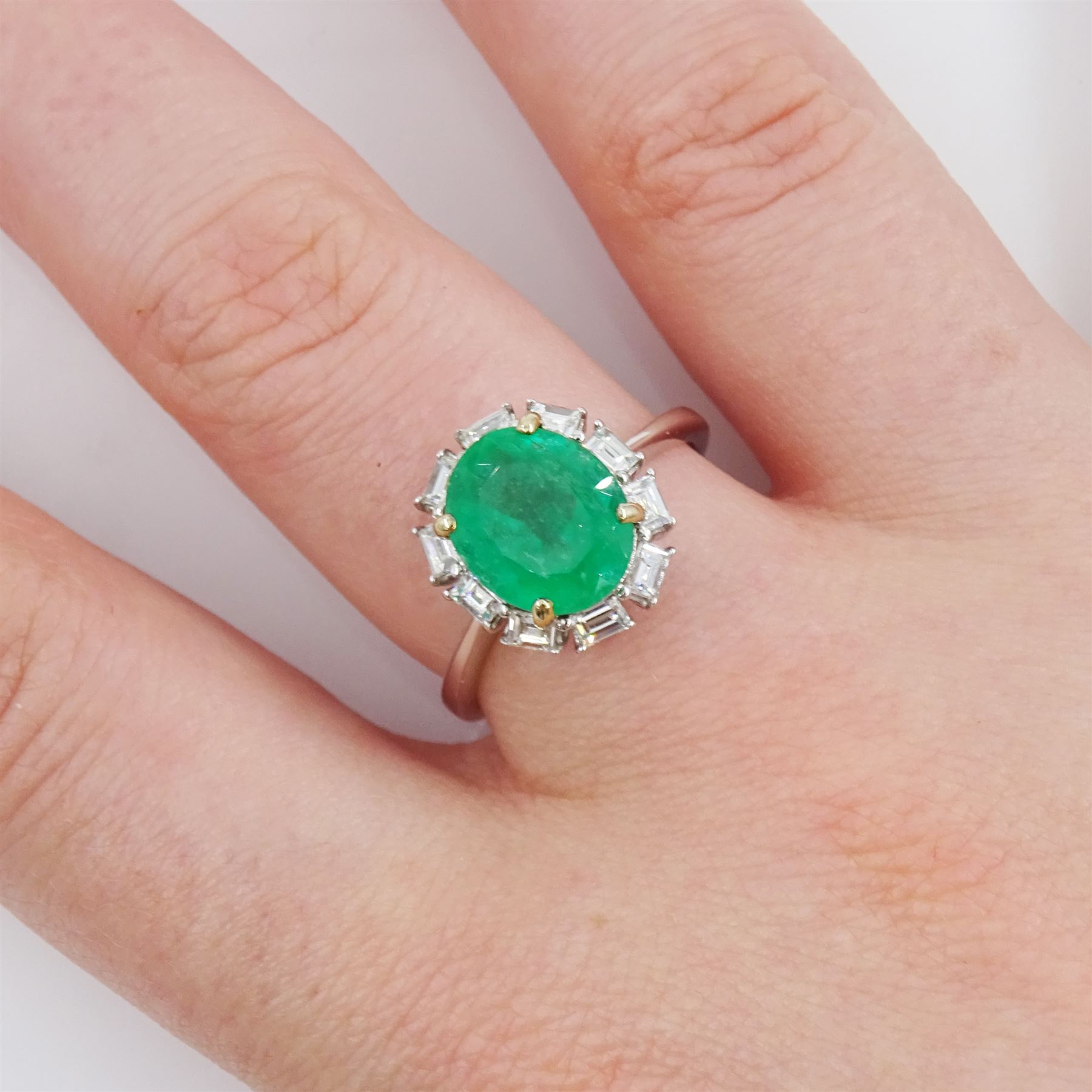 18ct white gold oval cut emerald and baguette cut diamond cluster ring, stamped 750, emerald approx 2.05 carat, total diamond weight approx 0.40 carat