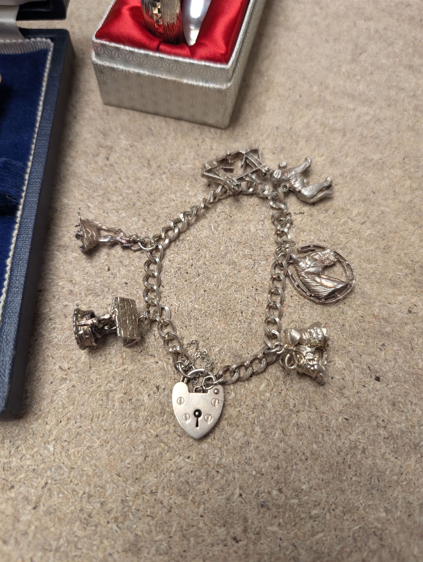 Silver charm bracelet, silver bangle, and cased set of silver spoons, all hallmarked 