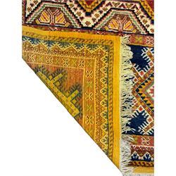 Persian Qashqai crimson ground rug, the field with central indigo and yellow medallion with geometric motifs, flanked by smaller medallions, border with repeating patterns (112cm x 200cm); Turkish Kazak light blue ground rug (109cm x 193cm); red ground runner with three octagonal medallions (69cm x 138cm)