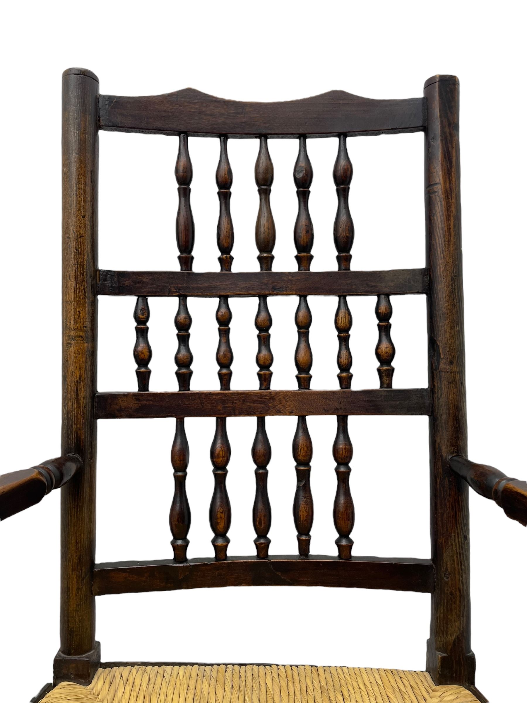 Matched set of twelve 19th century elm Lancashire spindleback dining chairs, shaped cresting rail over spindle back, rush seat, on turned supports united by turned stretchers, ring and globular turned front stretcher 