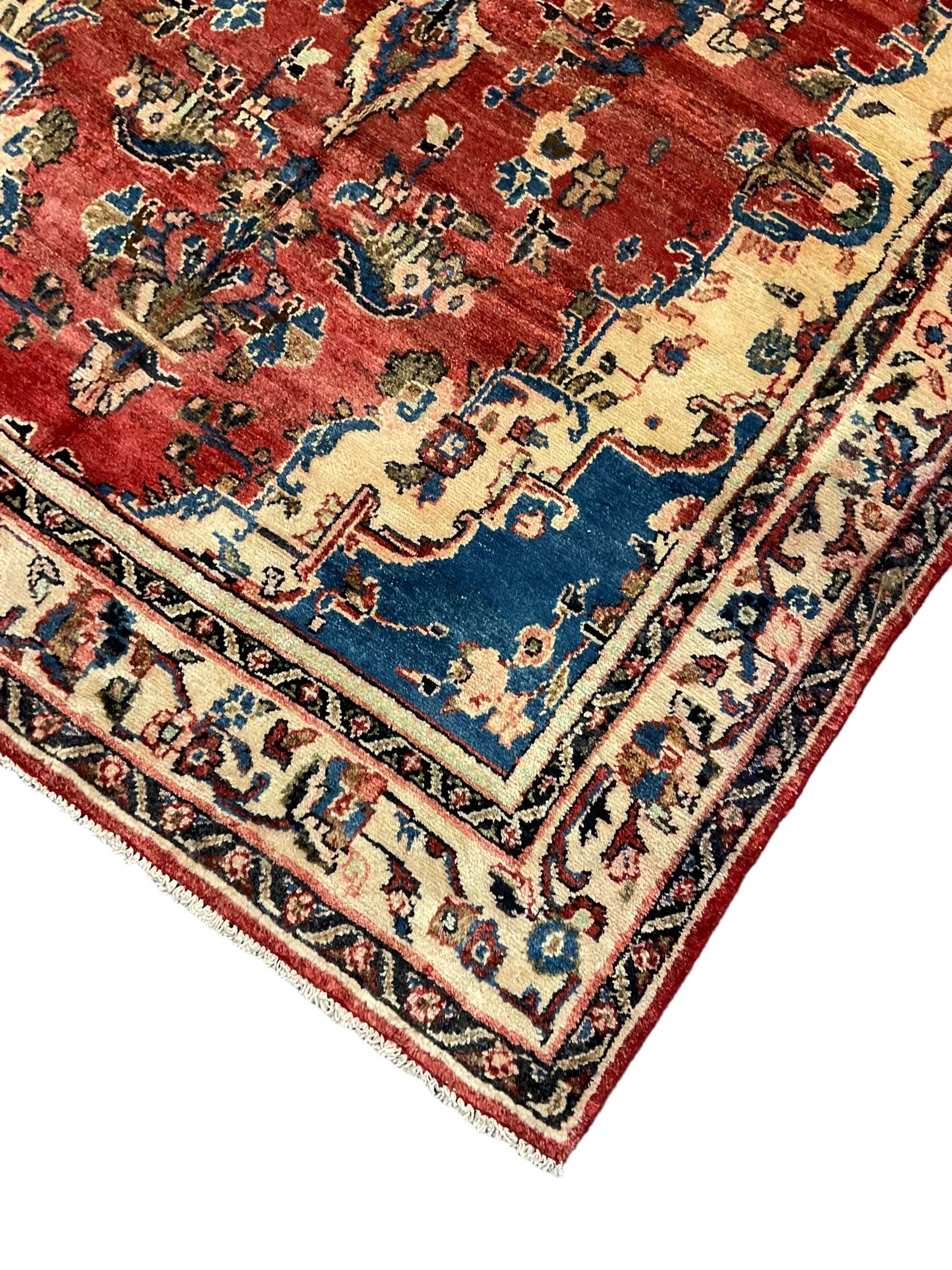 Persian Mahal red ground rug, central floral design pole medallion on a field decorated with flowerheads and foliage, the border decorated with trailing leafy branch and flowerheads 