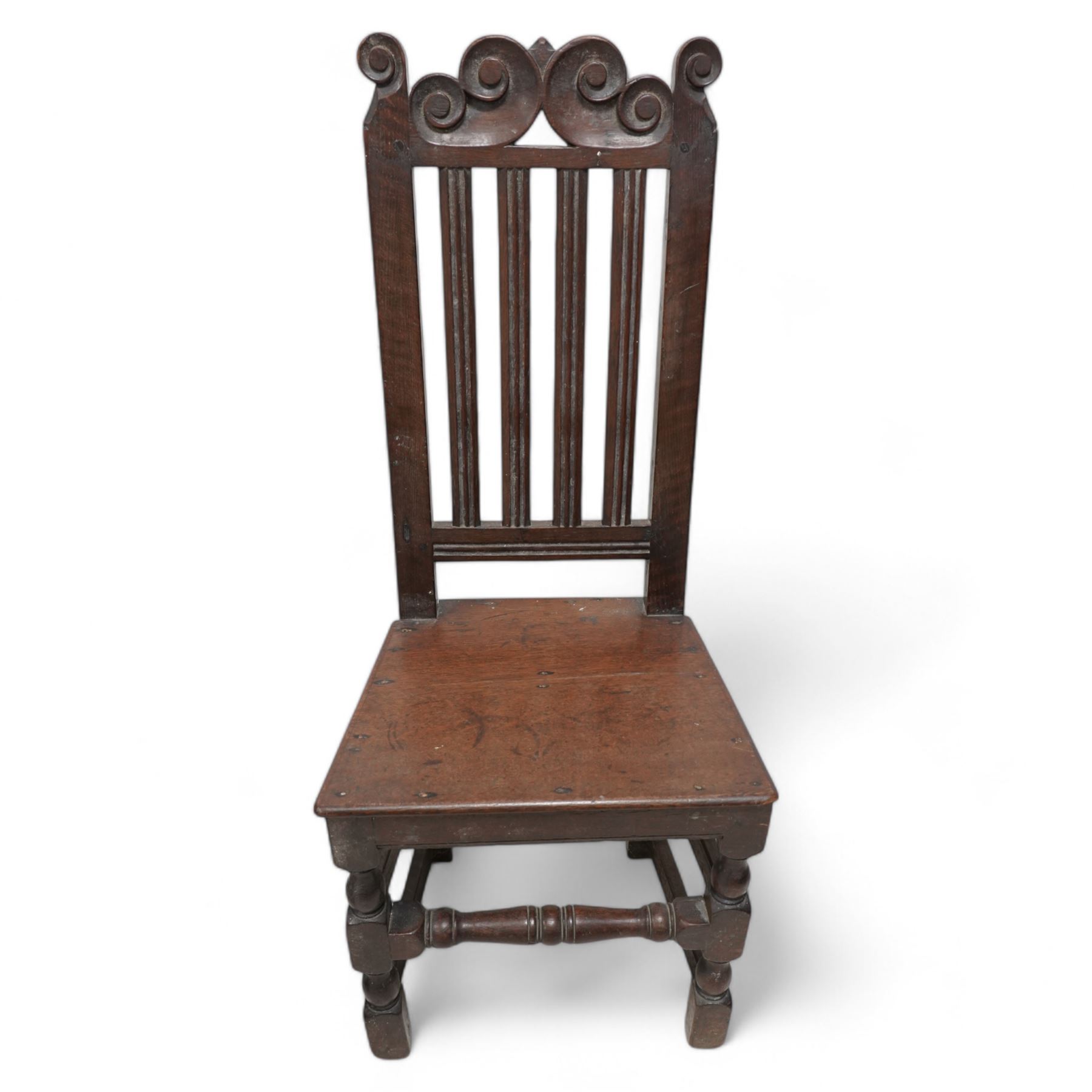 Mixed set of four 18th century oak side chairs, each with scroll carved pediment over vertical slat back, plank seat over turned and block supports