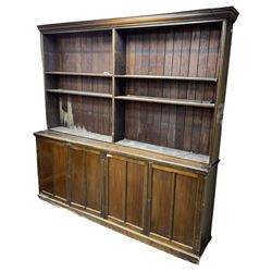 Large 20th century beech bookcase on cupboard, projecting cornice over shelves, the lower section enclosed by two double panelled cupboards, on plinth base