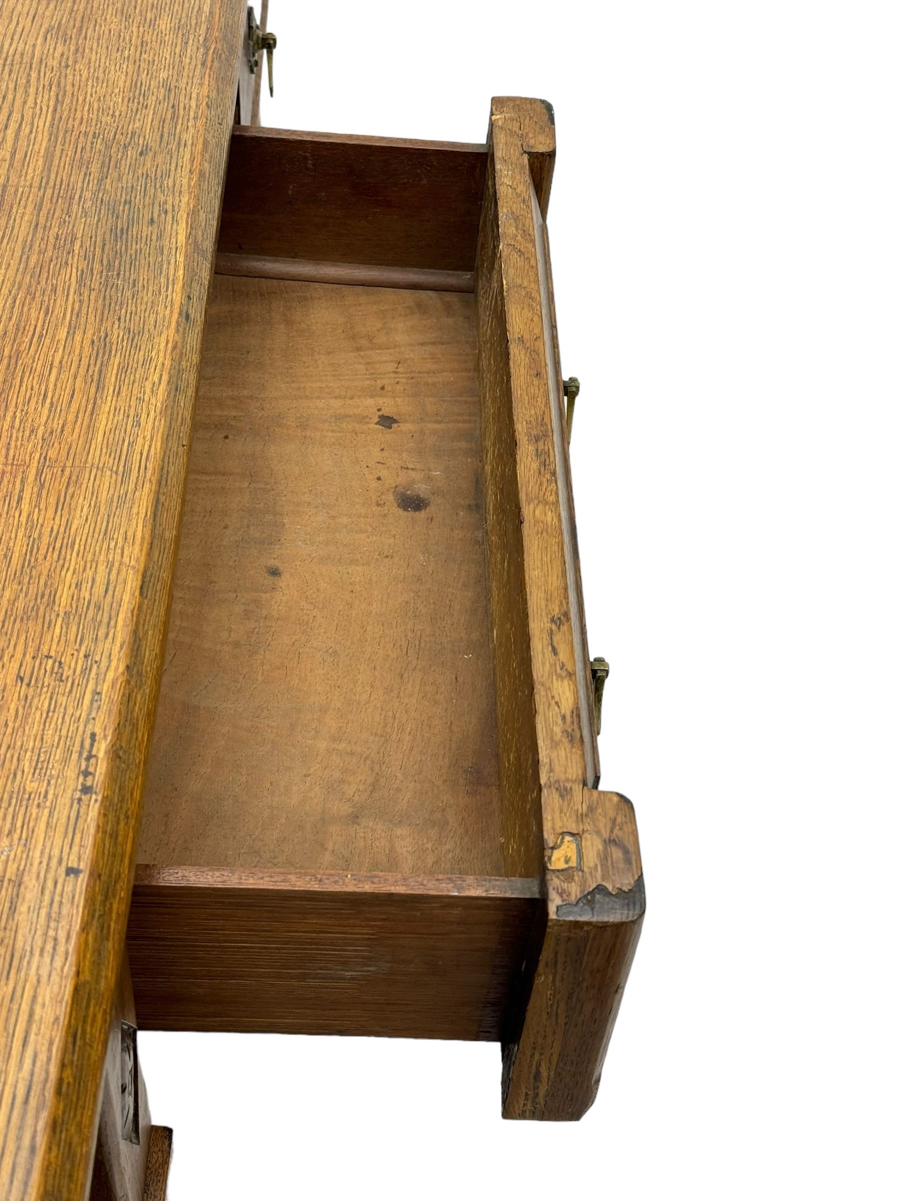 Late Victorian oak twin pedestal desk, chamfered rectangular top over three convex front edge drawers and two panelled cupboards, flanked by carved supports with roundels and diamond motif, on bracketed plinth base