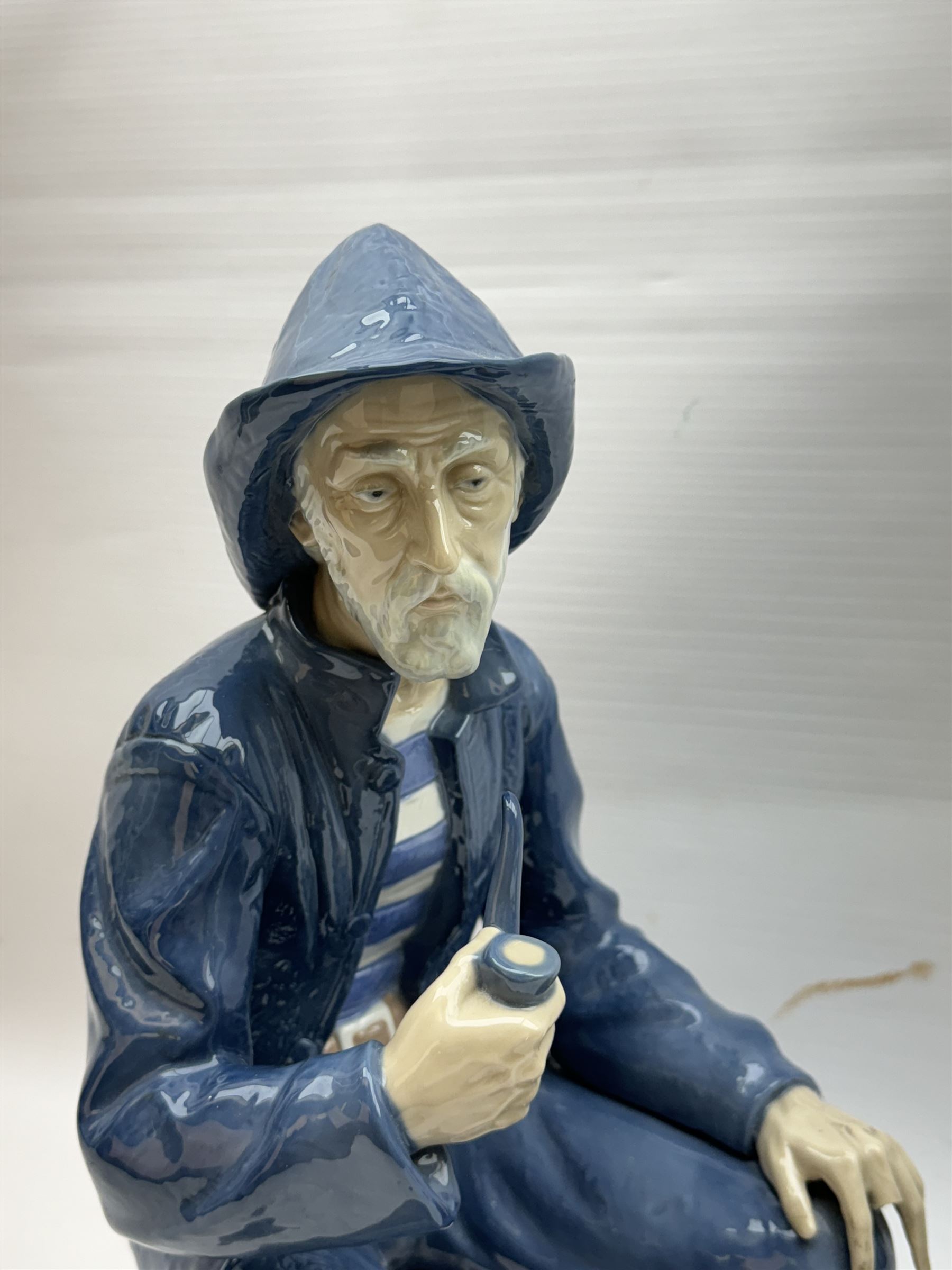 Lladro figure, Girl in Traditional Dress no 1159, together with Nao figure Old Fisherman Smoking a Pipe