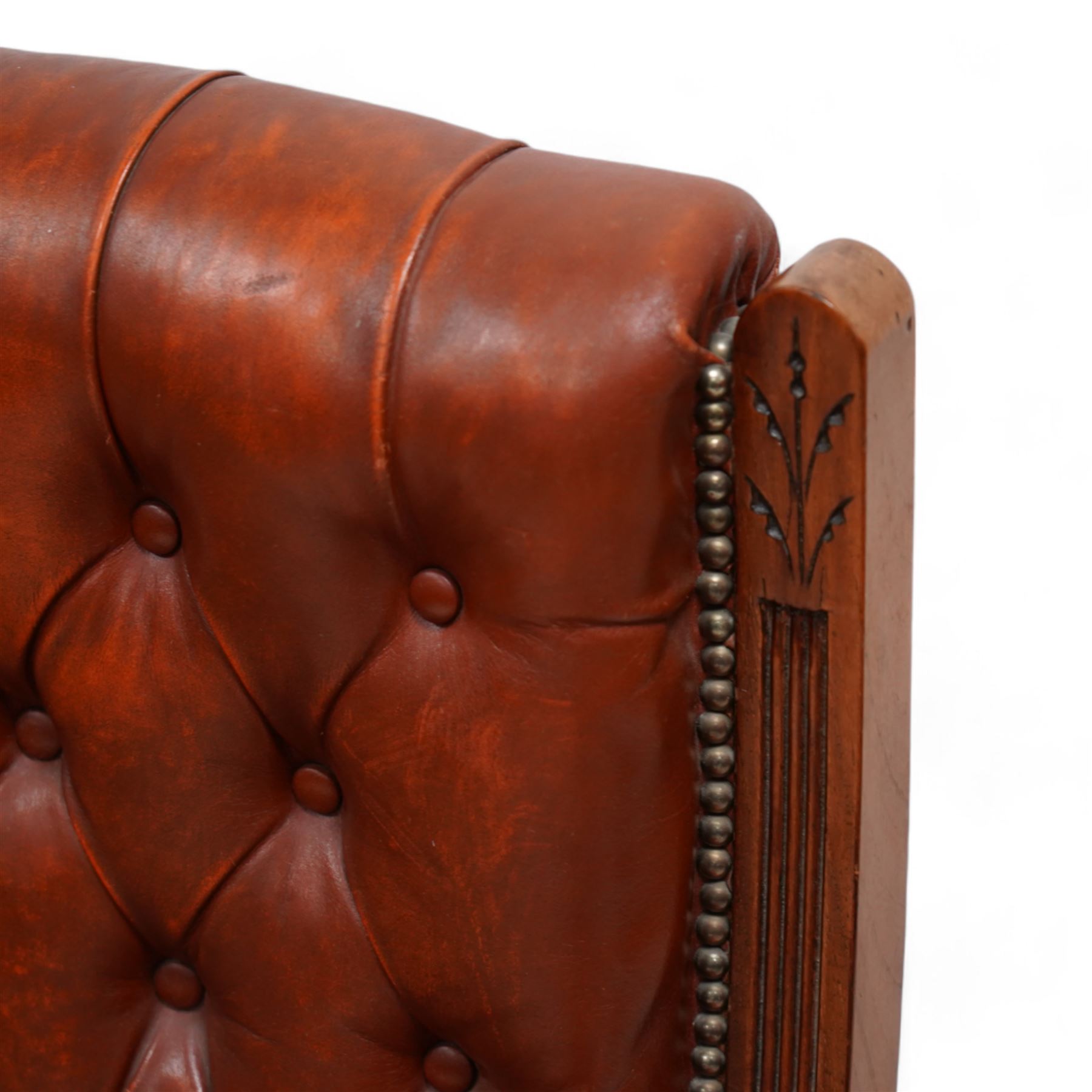 Late Victorian walnut matched two-piece salon suite upholstered in rust buttoned leather - open armchair, reed moulded frame and turned balustrade arm supports, on turned front feet with brass and ceramic castors (W60cm, H92cm, D70cm); nursing chair, fan carved cresting rail, moulded frame, on turned front feet (W58cm, H93cm, D73cm)