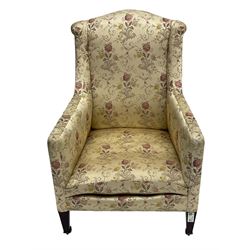 Edwardian hardwood-framed armchair, upholstered in floral pattern fabric, on square tapering front supports, brass and ceramic castors 