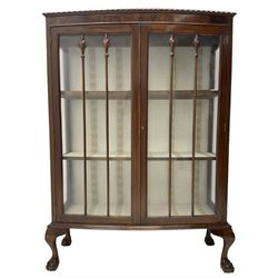 Early 20th century figured walnut bow-front display cabinet, enclosed by two glazed doors, on ball and claw cabriole feet