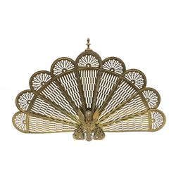 A brass peacock fire screen, with nine pierced fans, H62cm. 