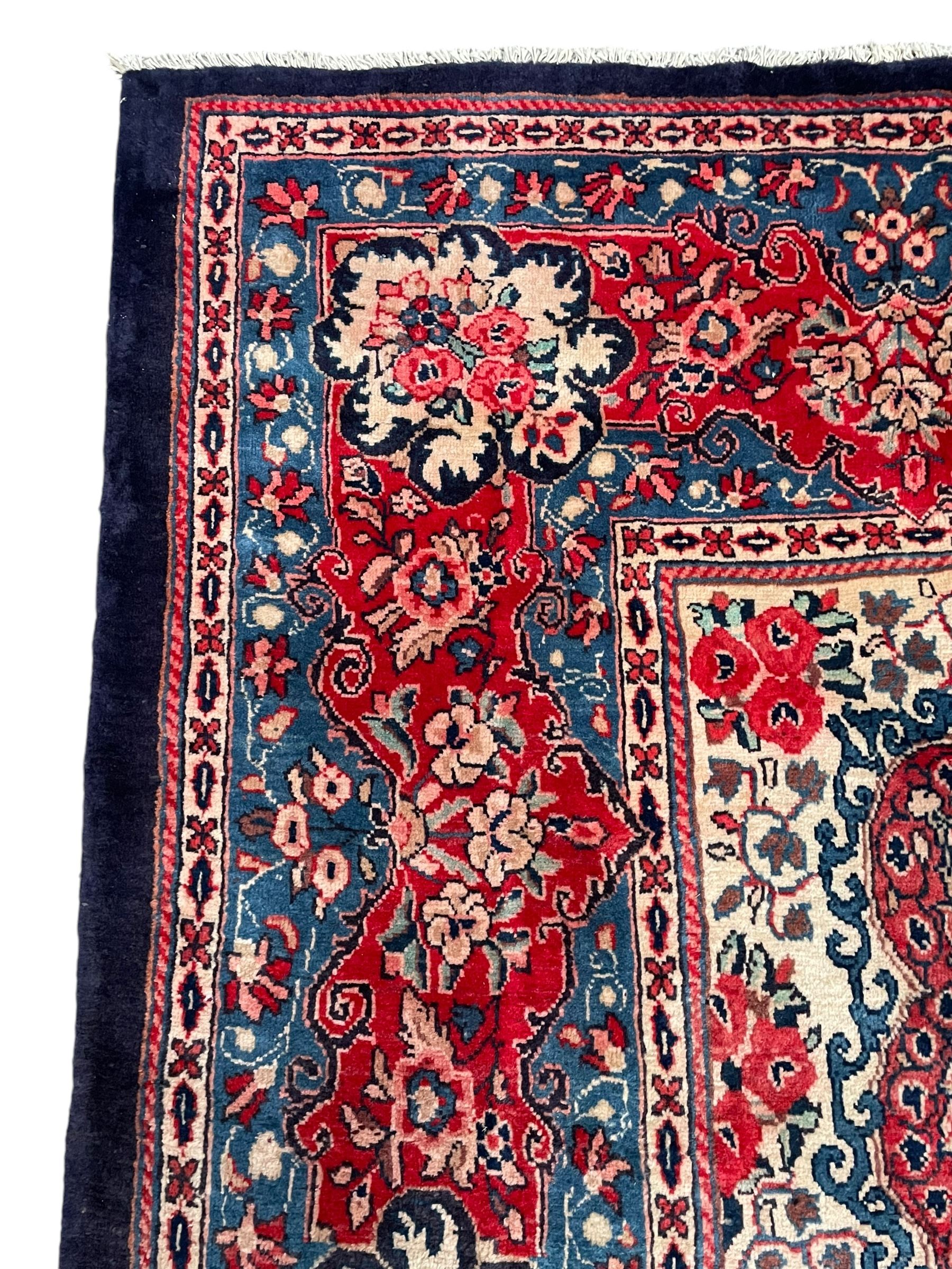 Persian Mahal indigo ground carpet, floral medallion on a field of swirling leafy branches and flower heads, shaped ivory field band decorated with flower head bouquets and trailing branches, the border decorated with floral motifs, within guard stripes