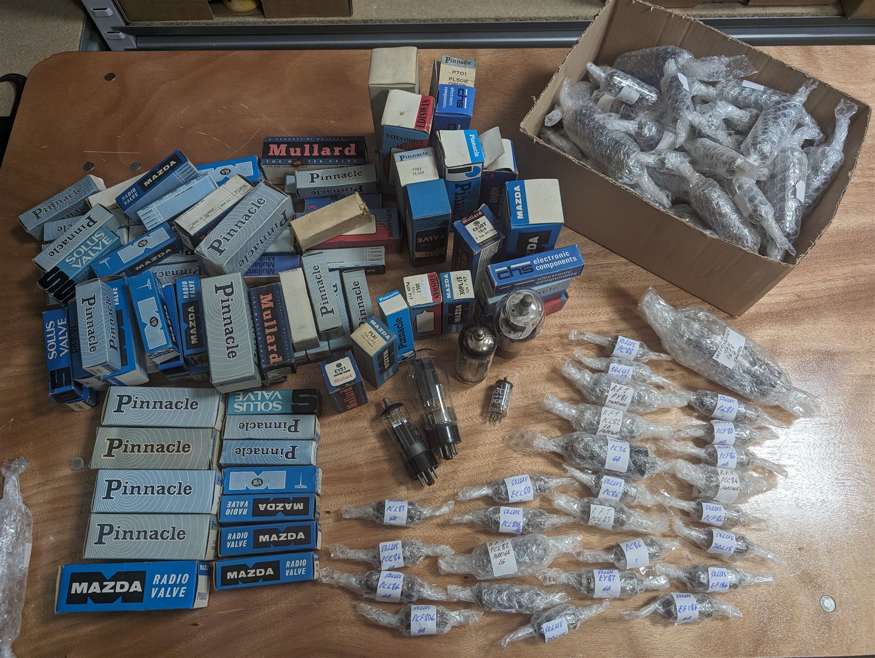 Large collection of thermionic valves/vacuum tubes, by various makers, mostly wrapped in bubble wrap with identifying stickers, together with a collection of empty valve boxes including Pinnacle, Mullard etc