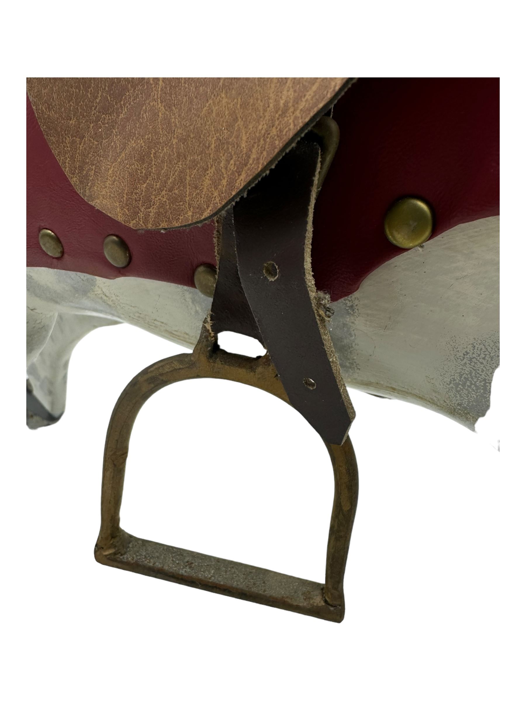 Mid 20th century rocking horse, dappled grey painted horse with applied mane and tail, red leather saddle and bridle accented with brass studs, supported by a stained wooden frame with turned supports and iron brackets, mounted on rockers