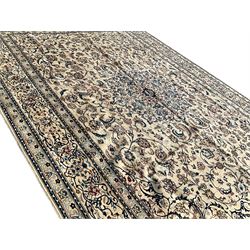 Persian Nain ivory ground carpet, the central rosette medallion surrounded by all over trailing indigo scrolling and foliate decoration with palmettes, the guarded border decorated with repeating Shah Abassi motifs, with stylised flower heads within the bands