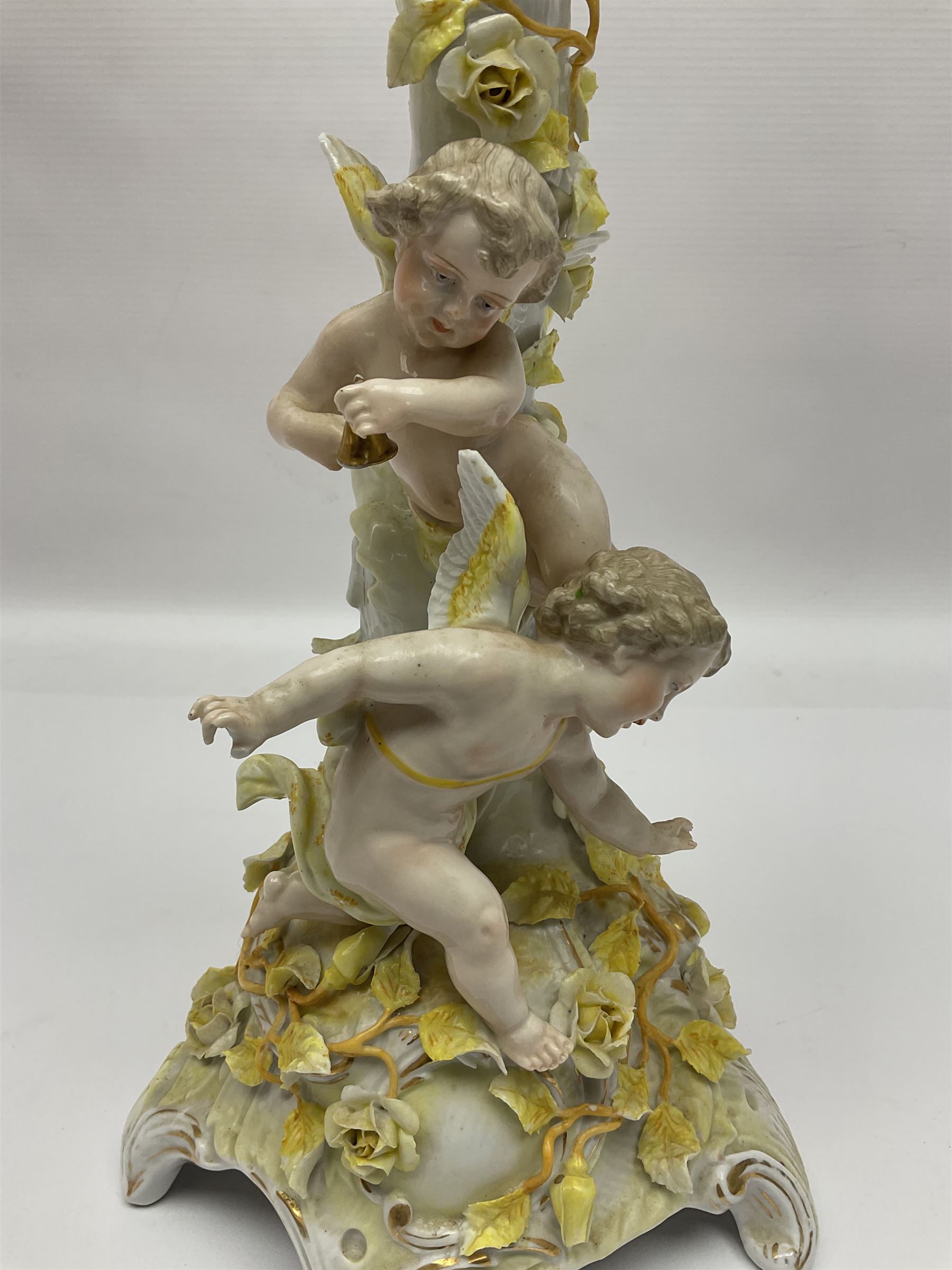 Dresden style candelabra, the central stem bordered by three branches, decorated with cherubs and yellow roses, H48cm