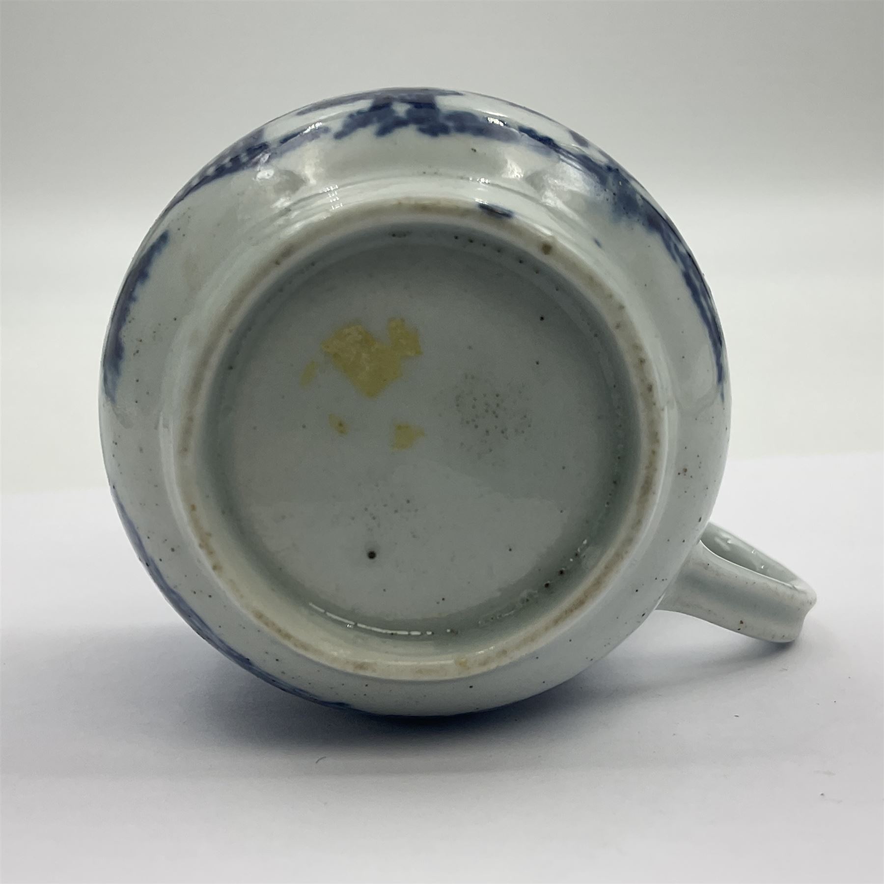 Two 18th century Worcester porcelain coffee cups, the first example decorated in the Plantation pattern, circa 1754, the second decorated in the Mansfield pattern, circa 1760, with workman's mark beneath, each approximately H5.5cm