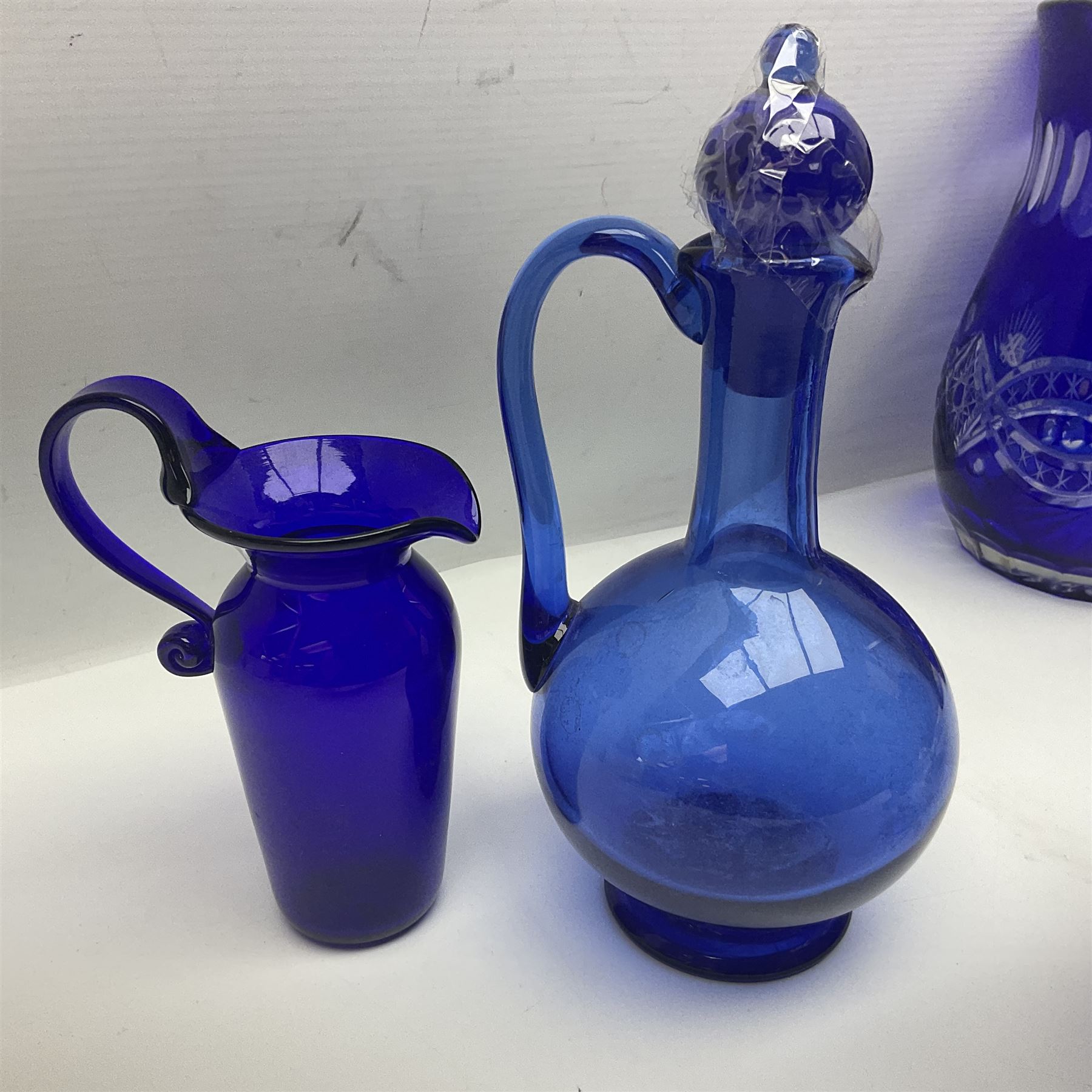 Bristol blue glass jug, together with blue claret jug, saucer, blue cut water jug, and seven matching glasses, water jug H22cm