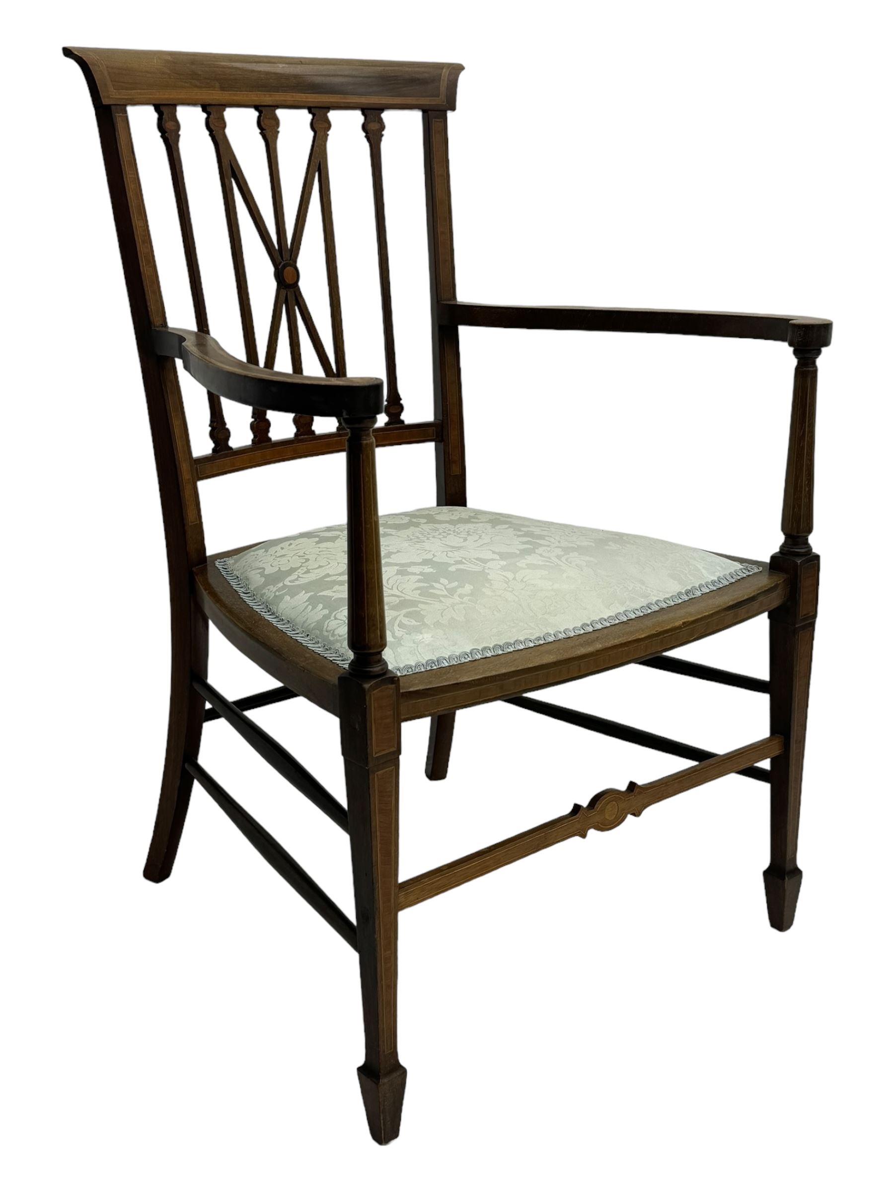 Edwardian inlaid mahogany armchair, curved top rail above spindle backrest with central X-shaped splat, the arms supported by turned uprights, over upholstered padded seat in pale blue damask fabric, on tapered supports with spade feet