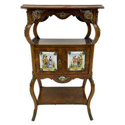 Mid-to-late 20th century French figured walnut three-tier bedside stand, shaped moulded top inlaid with figured book-matched veneers and crossbanding, double cupboard below enclosed by two doors mounted by painted porcelain panels depicting courting scenes within landscapes, on cabriole supports united by undertier, decorated with ornate cast metal cartouche mounts 