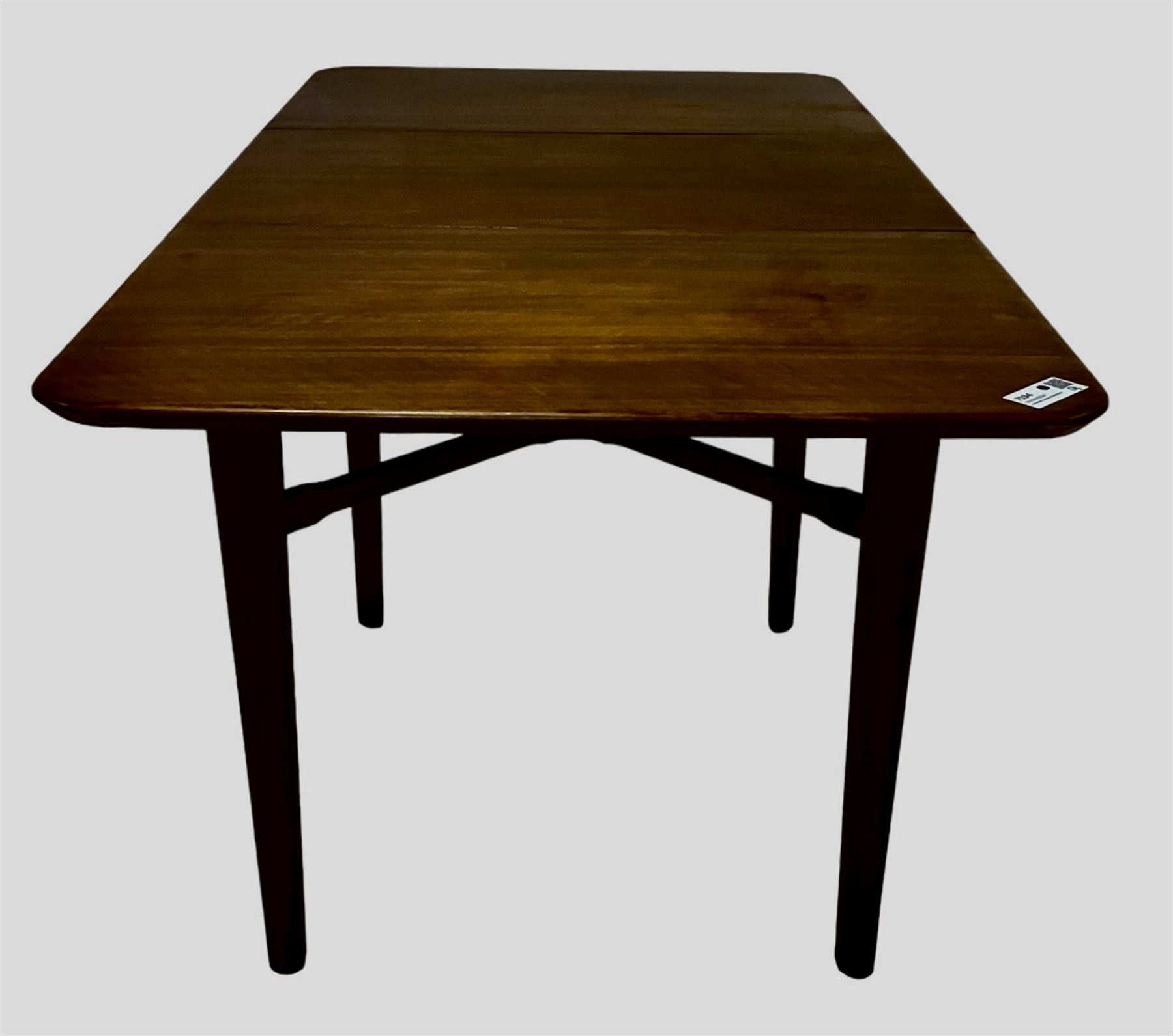 Mid-20th century teak extending dining table, rectangular top with rounded corners, raised on shaped tapering supports united by X-stretcher, with additional leaf