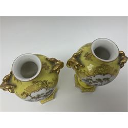 Pair of early 20th century Dresden vases with cover, of baluster form, decorated with figural panels within ornate gilt borders upon a yellow ground, with twin gilt goat mask handles, H16.5cm