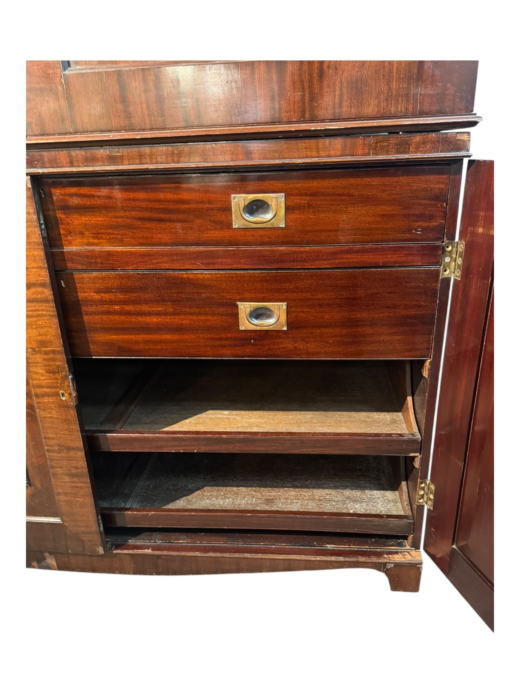 Victorian mahogany linen press, projecting cornice with dentil and scroll detailing, double panelled doors opening to an interior fitted with a brass hanging rail and coat hooks, lower section with two drawers and fitted shelves for additional storage, raised on bracket feet