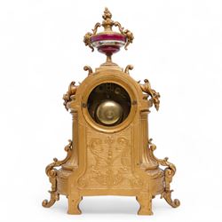 French - Late 19th century 8-day gilt metal and porcelain mounted clock c1880, the arched case above a plinth base on paw feet surmounted by an urn, porcelain dial with cartouche Roman numerals and steel spade hands, twin train rack striking movement, sounding the hours and half hours on a bell. With pendulum. 