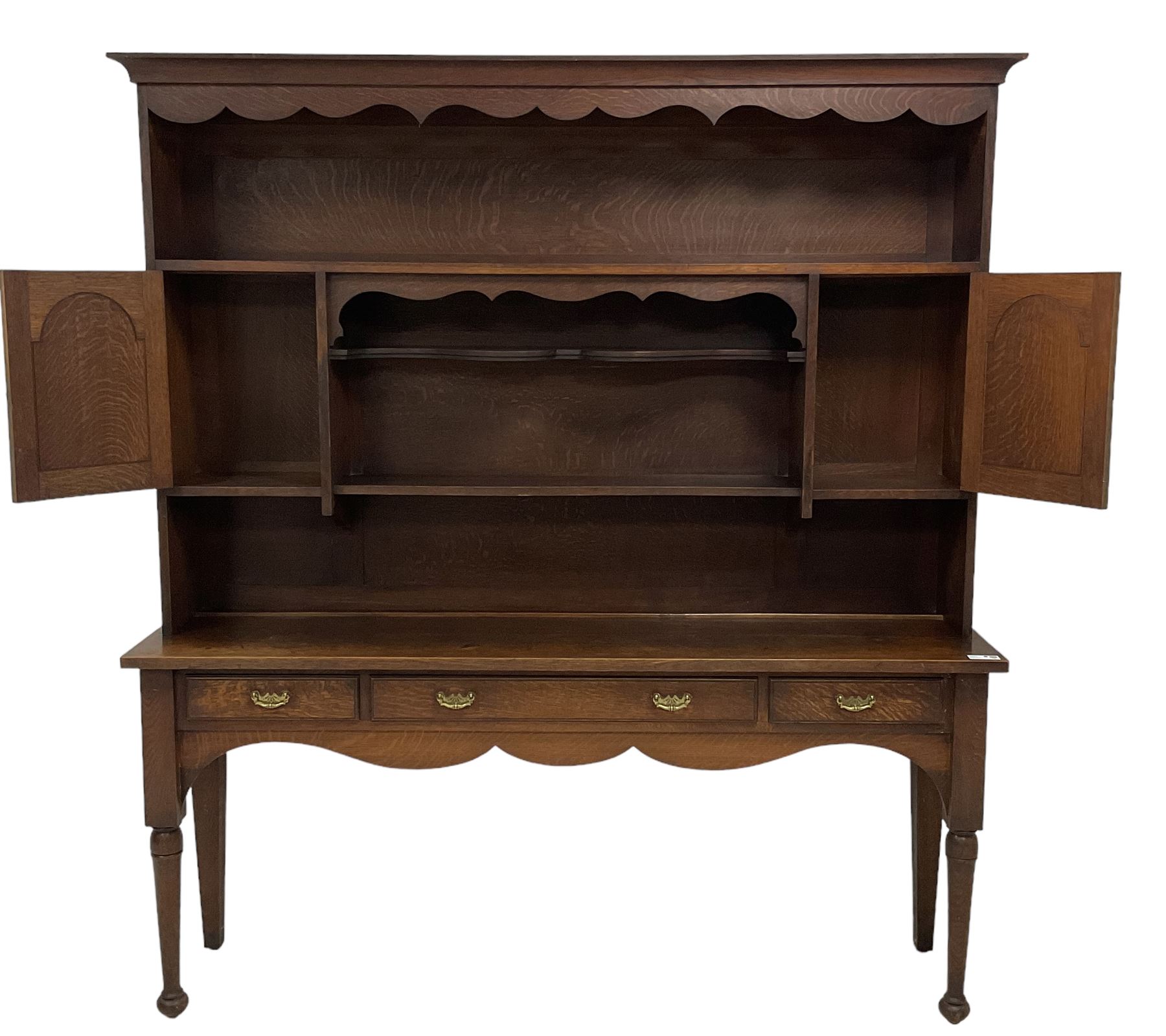 Early 20th century Georgian design oak dresser, projecting cornice with shaped apron over a three-tier plate rack with flanking fielded spice cupboards, the base fitted with three drawers, on turned supports