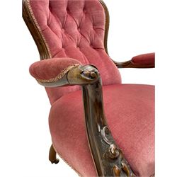 Victorian carved walnut open armchair, foliate carved cresting rail over butted back and sprung seat, upholstered in pink velvet scrolled arm terminals with moulded scrolling vines terminating to cabriole supports and ceramic castors