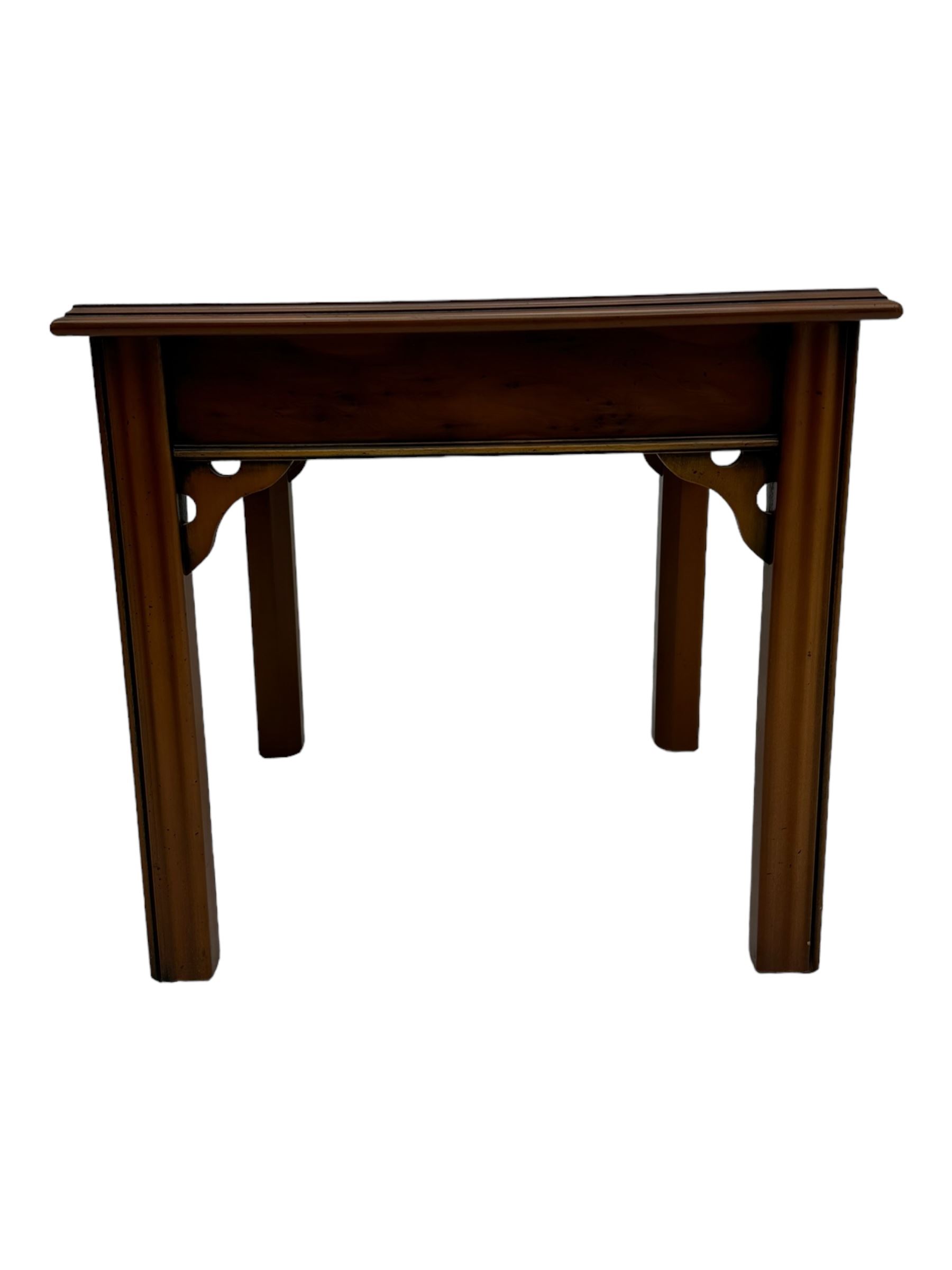 20th century pair of yew wood lamp tables, moulded square top with pierced corner brackets, on fluted straight supports 