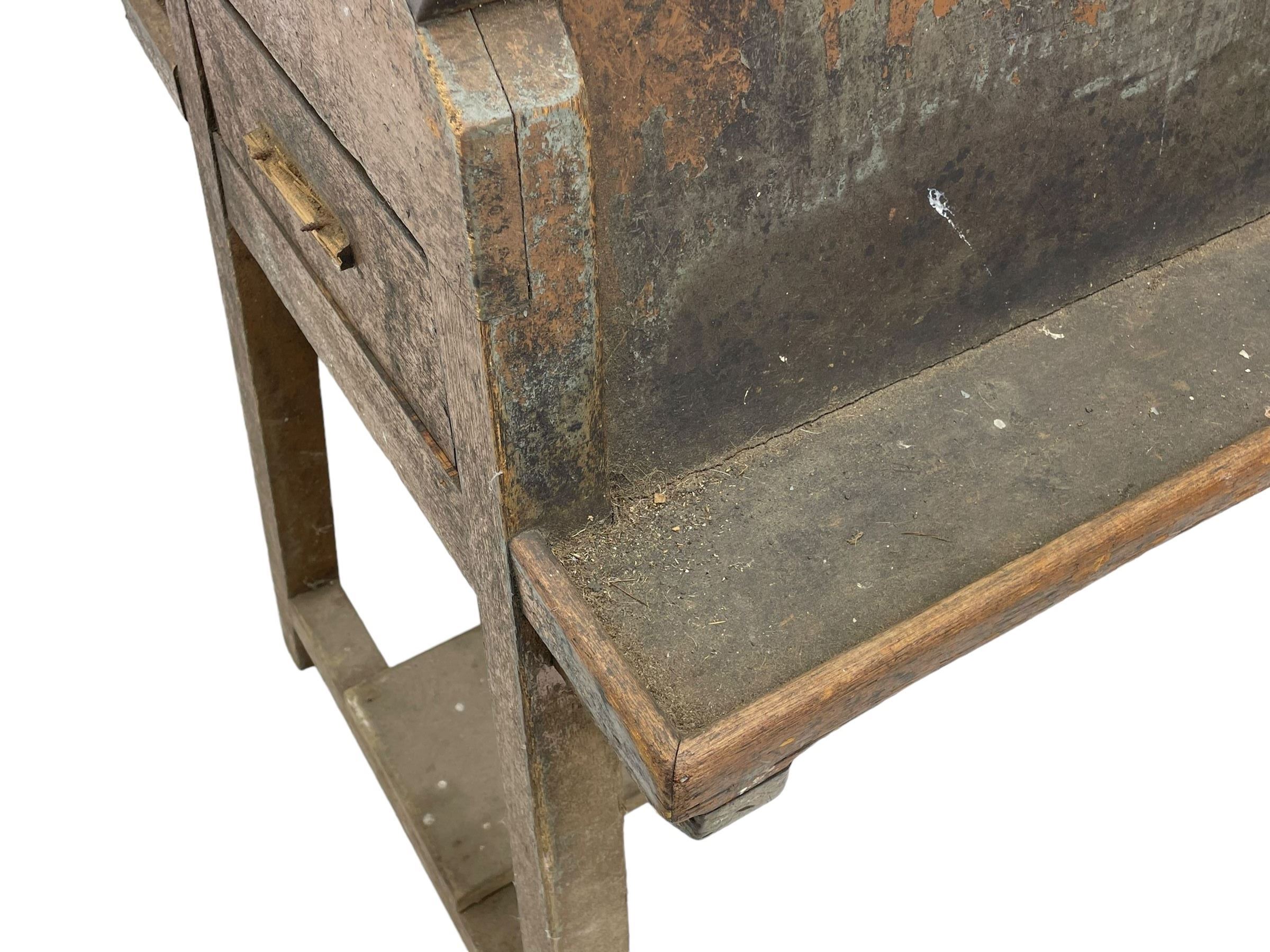 19th century teak saddle horse, A-frame on trestle base, fitted with shelves at either side and end drawers, on square supports united by undertier 