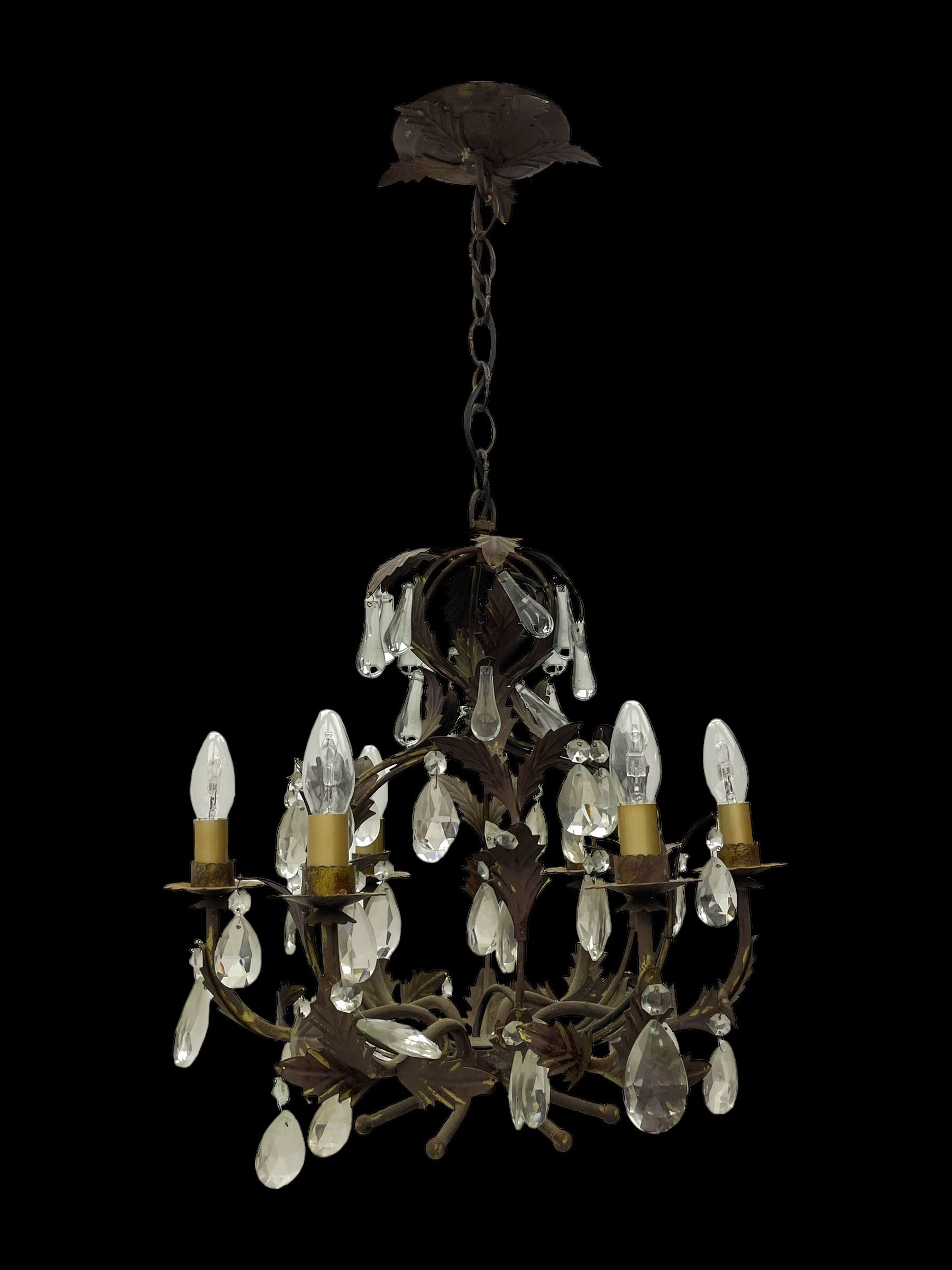 Early 20th century wrought metal chandelier, of scrolled form with six branches, decorated with leafage and glass pendants 