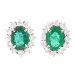 Pair of 18ct white gold oval cut emerald and round brilliant cut diamond cluster stud earrings, hallmarked, total emerald weight approx 2.00 carat, total diamond weight approx 1.20 carat