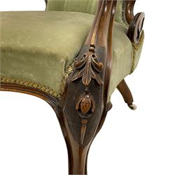 Pair of lady's and gentleman's Victorian carved walnut armchair and nursing chair, foliate carved cresting rail over shaped back with scrolled acanthus carved sides, the armchair with scroll arm terminals, the spoon back and sprung seat upholstered in buttoned sage green velvet, raised on cabriole supports with bell-flower moulded knees and scroll feet, on ceramic castors