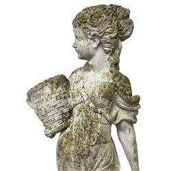 Weathered and painted cast stone garden statue, in the form of an Italian maiden carrying baskets with gathered flora and berries, on a shaped ovoid base