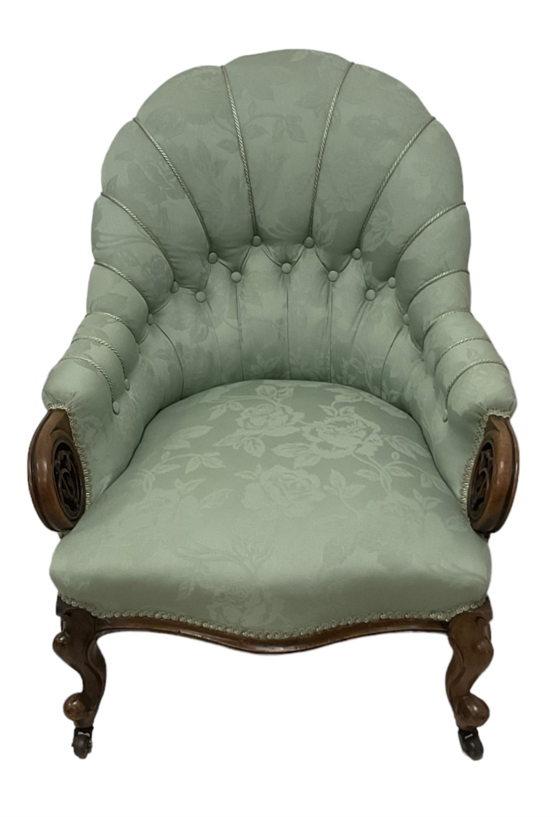 19th century mahogany framed fan-back armchair, upholstered in buttoned turquoise floral damask fabric with spring seat and pearlescent piping, pierced and carved arm terminals with floral motif, over serpentine fronted seat, raised on cartouche carved cabriole supports with castors