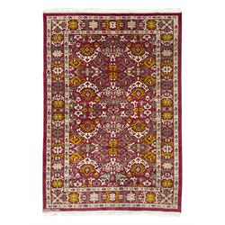 Persian design red ground rug, decorated with stylised plant motifs, repeating border with...