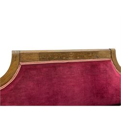 Late Victorian inlaid walnut two seat settee, the shaped cresting rail decorated with foliate inlays and boxwood stringing, upholstered in crimson velvet with sprung seat, raised on turned and fluted supports with ceramic castors