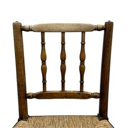 Set of four 19th century elm spindle back chairs, bar cresting rail over three turned vertical spindles, rush seat on turned supports united by turned stretchers 